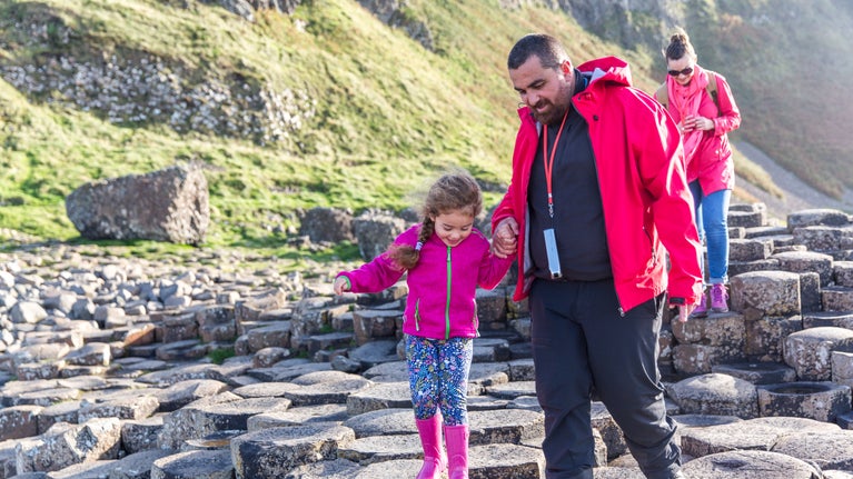 A family pick their way across a path formed of hexagonal-shaped stones